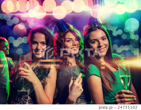 smiling friends with glasses of champagne in club 24755102