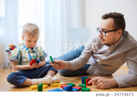 father and son playing with toy blocks at home 24755673