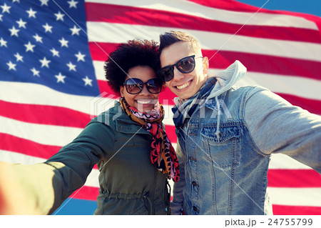 happy couple taking selfie over american flag 24755799