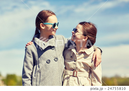 happy little girls hugging and talking outdoors happy little girls hugging and talking outdoors 24755810