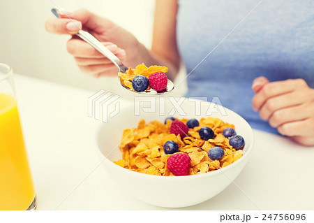 close up of woman eating corn flakes for breakfast close up of woman eating corn flakes for breakfast 24756096
