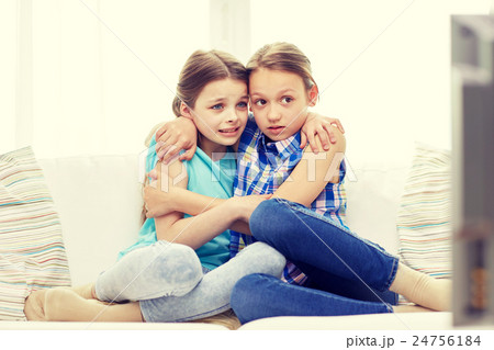 scared little girls watching horror on tv at home 24756184