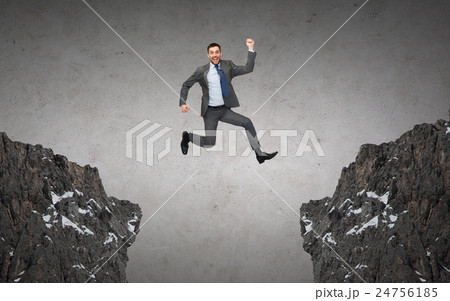 happy smiling businessman jumping between rocks 24756185