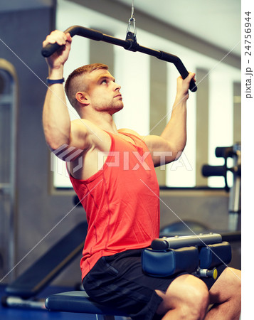 man flexing muscles on cable machine gym man flexing muscles on cable machine gym 24756944