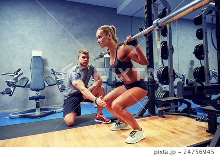 man and woman with bar flexing muscles in gym 24756945
