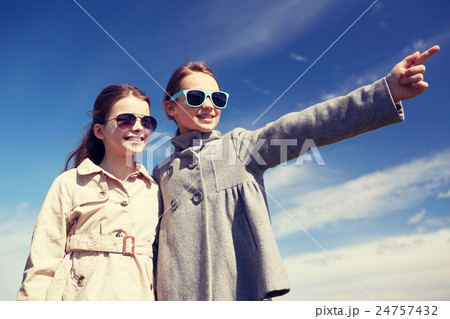 happy little girls hugging and pointing finger 24757432