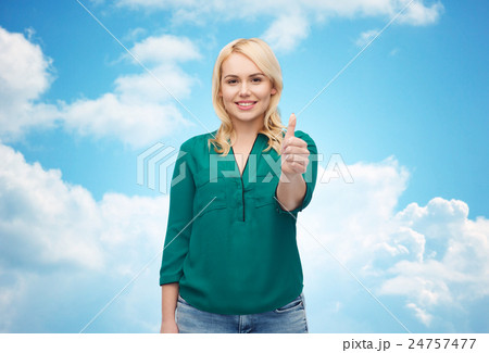 smiling young woman in shirt showing thumbs up 24757477