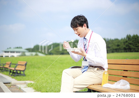 ビジネスマン 男性 サラリーマン 30代 会社員 ベンチ 椅子 座る 公園 晴れ スーツ の写真素材