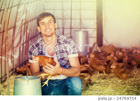 Happy countryman holding brown chicken Happy countryman holding brown chicken 24769754
