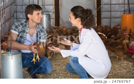 Woman veterinarian chatting with farm worker 24769767