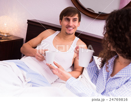 Couple drinking coffee in the bed. Couple drinking coffee in the bed. 24769816