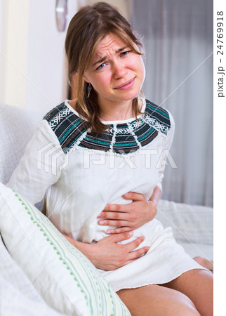 Unhappy girl holding hands on stomach Unhappy girl holding hands on stomach 24769918