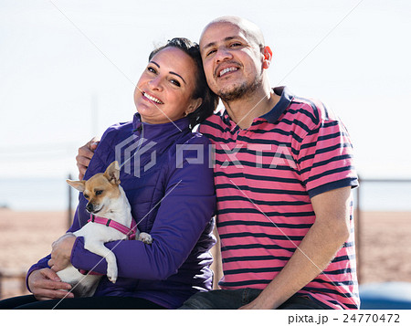 man, woman and dog on the beach 24770472