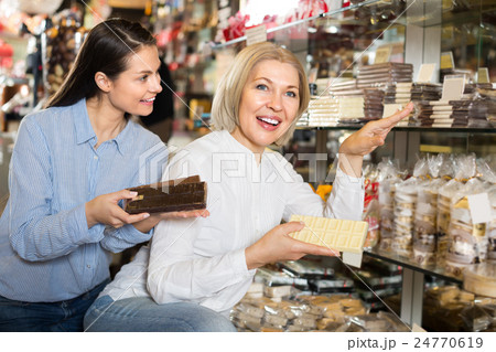 Happy women buying chocolate bars . 24770619