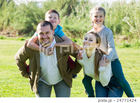 Parents holding kids on shoulders Parents holding kids on shoulders 24771424