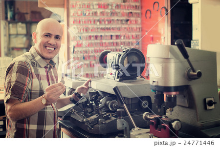 Workman making duplicates of keys . Workman making duplicates of keys . 24771446