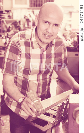 Efficient senior man doing vehicle numbers on machine Efficient senior man doing vehicle numbers on machine 24771491