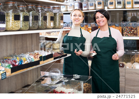 Two female sellers wearing apron Two female sellers wearing apron 24771525