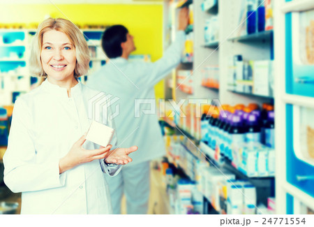 Pharmacist and pharmacy technician posing in drugstore Pharmacist and pharmacy technician posing in drugstore 24771554