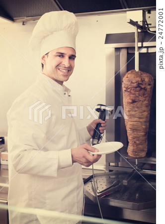 Ordinary arabian cook posing near meat for kebab 24772001