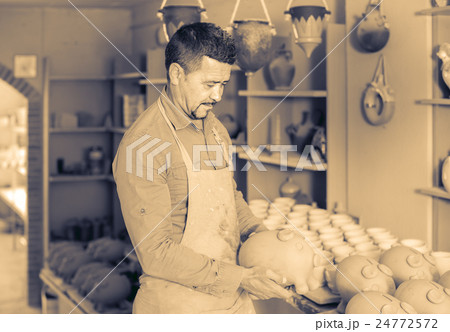 man potter holding ceramic vessels in atelier man potter holding ceramic vessels in atelier 24772572