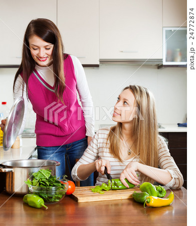 Two young women cooking together 24772874