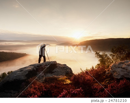 Professional use camera and tripod on peak of rock 24781210