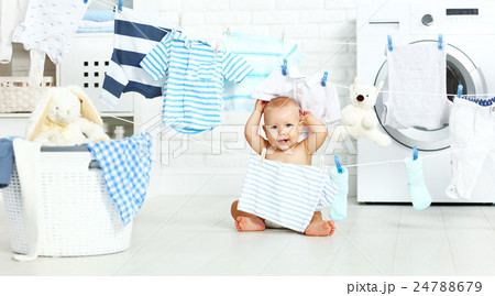 fun happy baby boy  to wash clothes and laughs in laundry 24788679