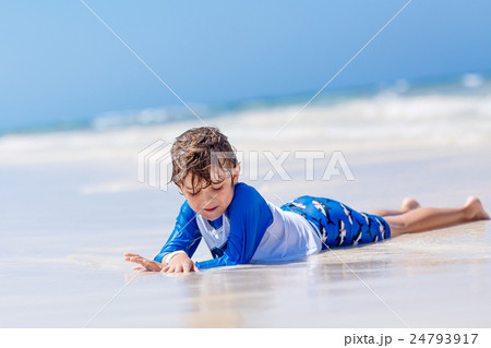 little blond kid boy having fun on tropical beach 24793917