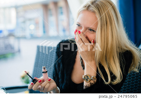 young beautiful blonde girl is sitting in a street 24795065