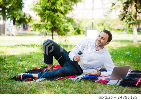 Businessman working in the garden and eating lunch 24795135
