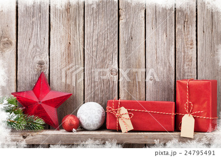 Christmas gift boxes and decor in front of wall 24795491