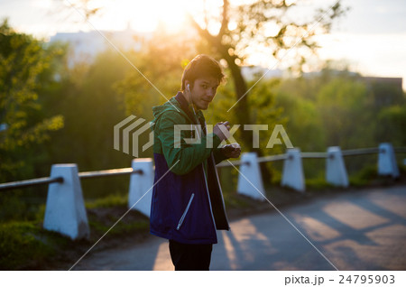 Common young man walking in the city listening to Common young man walking in the city listening to 24795903
