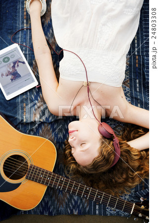 Girl Guitar Earphones Digital Device Lie Down Concept 24803308