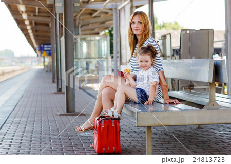 Cute little girl and mother on a railway station. Cute little girl and mother on a railway station. 24813723