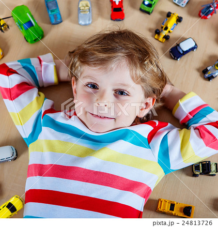 Little blond child playing with lots of toy cars Little blond child playing with lots of toy cars 24813726