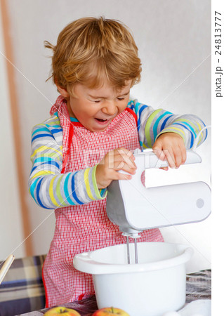 Funny blond kid boy baking apple cake indoors Funny blond kid boy baking apple cake indoors 24813777