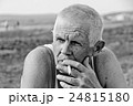An elderly man smokes 24815180