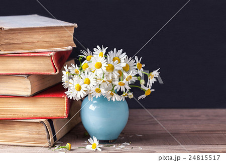 Old vintage books with bouquet of daisies. 24815517