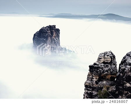 Sharp rock empire sticking out from heavy fog. Sharp rock empire sticking out from heavy fog. 24816807