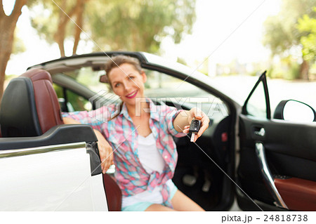 Woman sitting in a convertible car with the keys Woman sitting in a convertible car with the keys 24818738