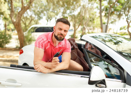 Man standing near convertible with keys in hand 24818739