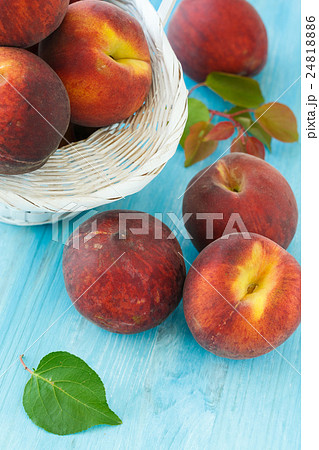 Ripe peaches in basket on  wooden background 24818886