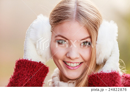 Pretty smiling woman in white earmuffs. 24822876