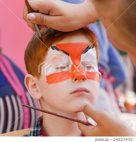 Child boy face painting, making tiger eyes process Child boy face painting, making tiger eyes process 24823430