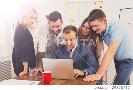 Happy business people team together look at laptop Happy business people team together look at laptop 24823712