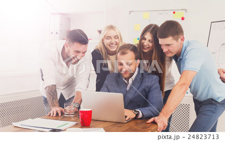 Happy business people team together look at laptop 24823713