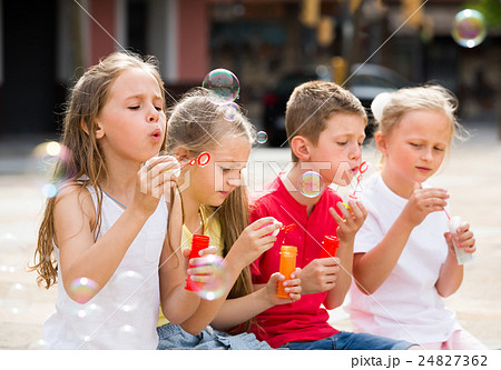 Four glad kids blowing soap bubbles 24827362