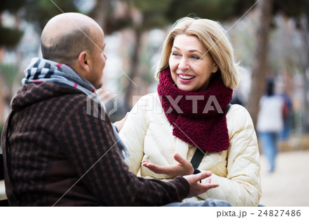 Mature couple chatting in street Mature couple chatting in street 24827486