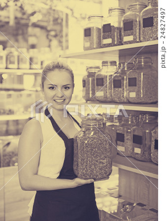 Smiling woman holding glass can with herbs 24827497